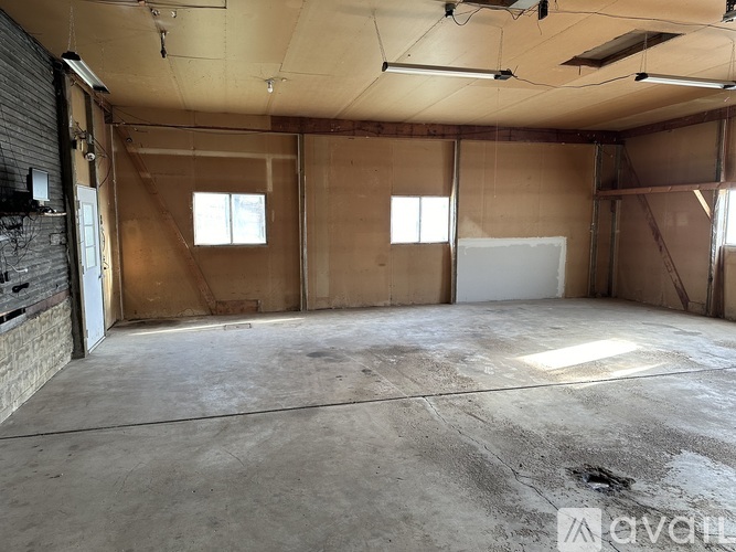 A large, empty room with a concrete floor and walls covered in insulation material.