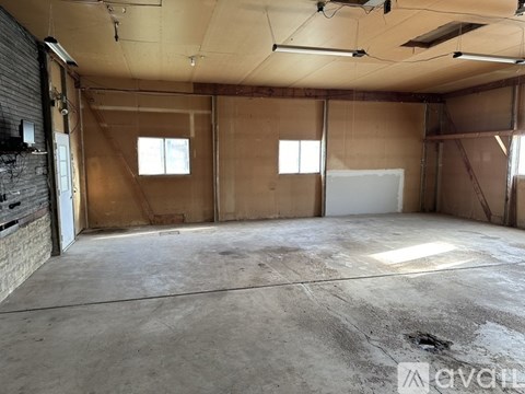 A large, empty room with a concrete floor and walls covered in insulation material.