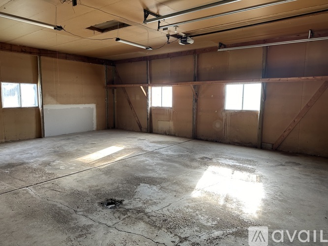 A large, empty room with concrete floors and exposed ceiling beams.
