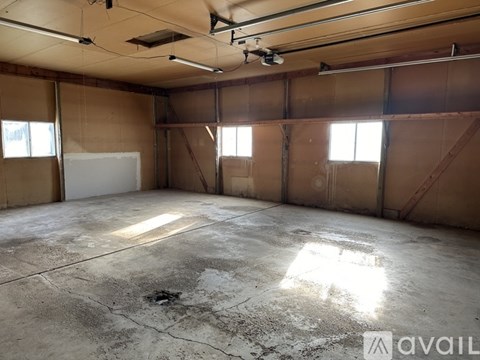 A large, empty room with concrete floors and exposed ceiling beams.