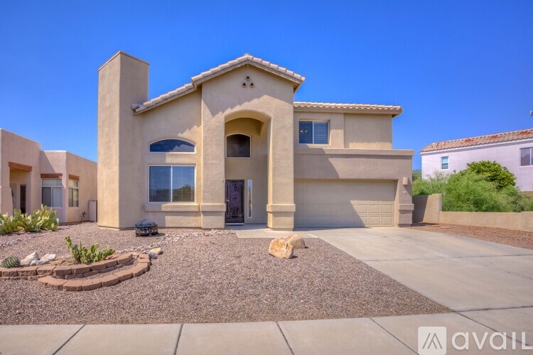 A house with a beige exterior and a gravel driveway in front.
