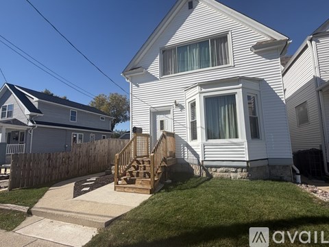 A house with a wooden staircase leading to the front door.