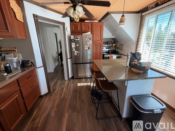 A kitchen with wooden cabinets and a stainless steel refrigerator.