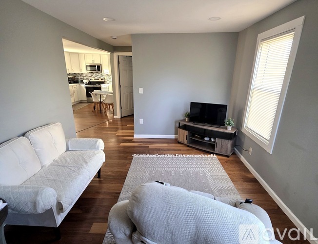 A living room with a white couch and a television.