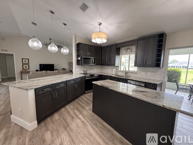 A kitchen with dark wood cabinets and a marble countertop.