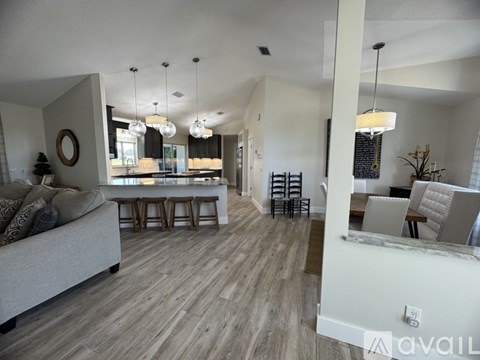 A living room with a grey sofa and wooden flooring.