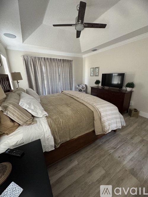 A bedroom with a large bed and a television on a stand.