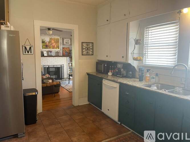 A kitchen with a refrigerator on the left and a sink on the right.