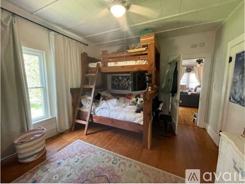 A bedroom with a bunk bed and a rug on the floor.