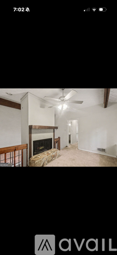 A room with a fireplace and a ceiling fan.
