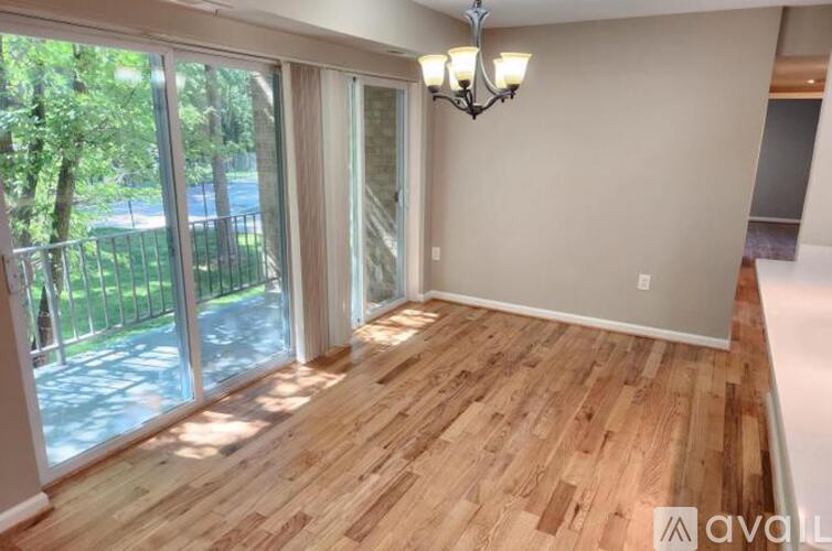 A room with wooden flooring and a chandelier.