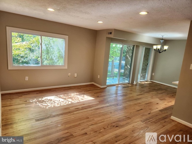 A room with wooden flooring and a large window.