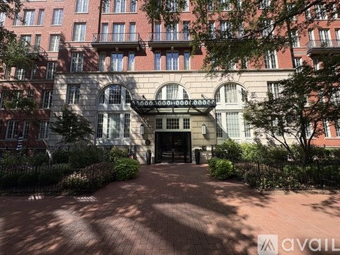 A building with a large arched entrance and a brick walkway leading to it.