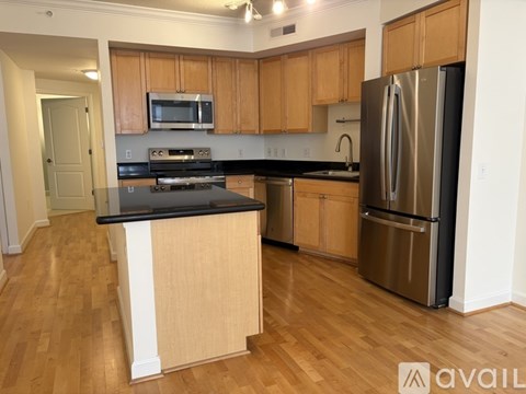 A kitchen with wooden cabinets and a black countertop.