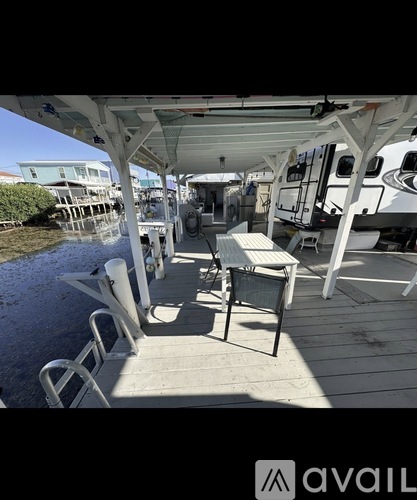 A white boat with a table and chairs on the deck.