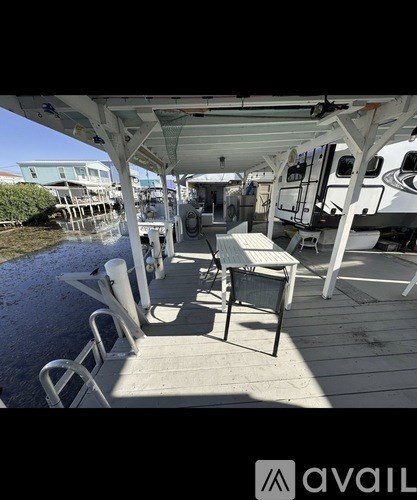 A white boat with a table and chairs on the deck.