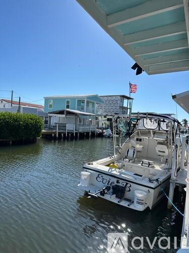 A boat named Eoie B is docked in calm waters.