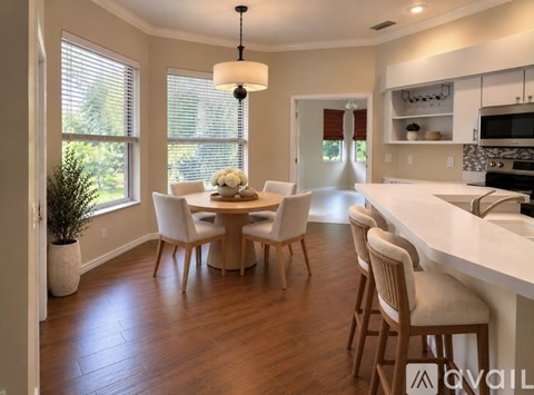 A modern dining room with a white table and chairs.