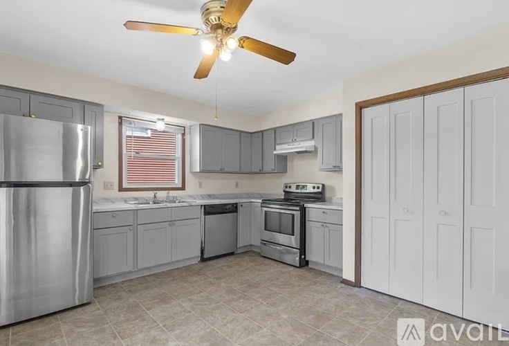 A kitchen with a refrigerator, oven, and sink.