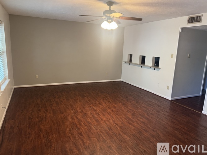 A room with wooden flooring and a ceiling fan.