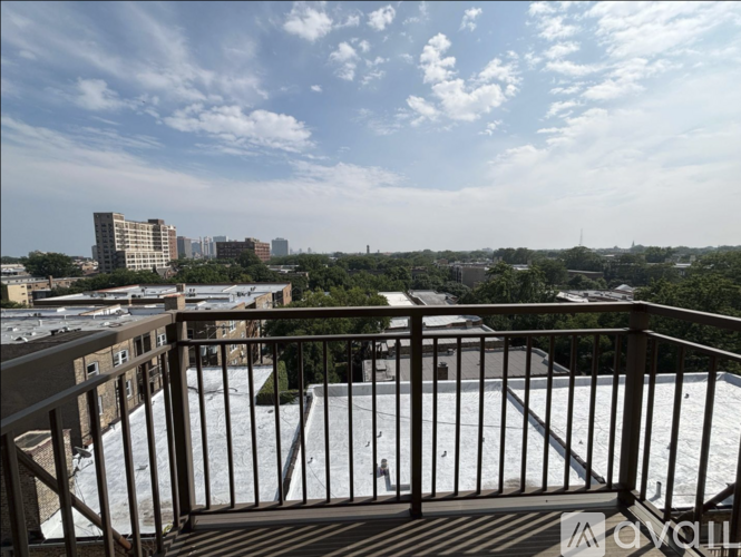 A balcony with a metal railing overlooks a cityscape.