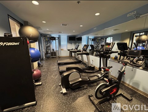 A gym with a variety of equipment including treadmills, exercise balls, and weight machines.