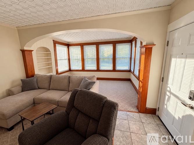 A living room with a grey couch and a brown chair.