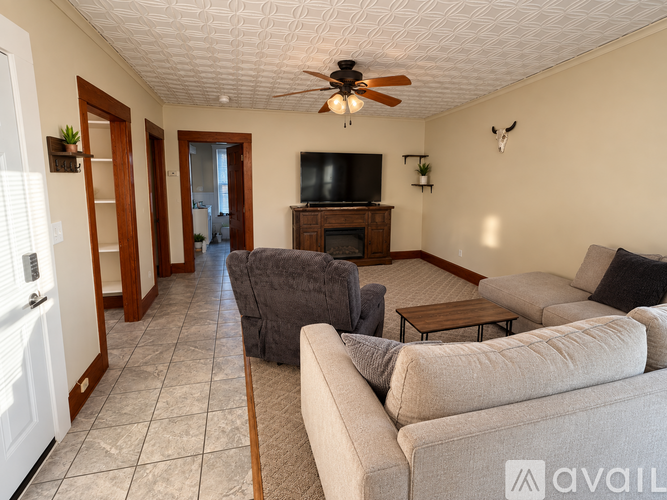 A living room with a grey couch and a wooden entertainment center.