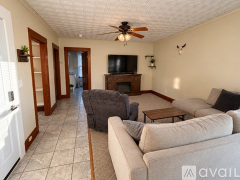 A living room with a grey couch and a wooden entertainment center.
