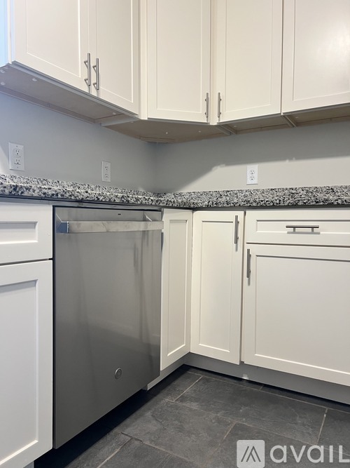 A kitchen with a granite countertop and white cabinets.
