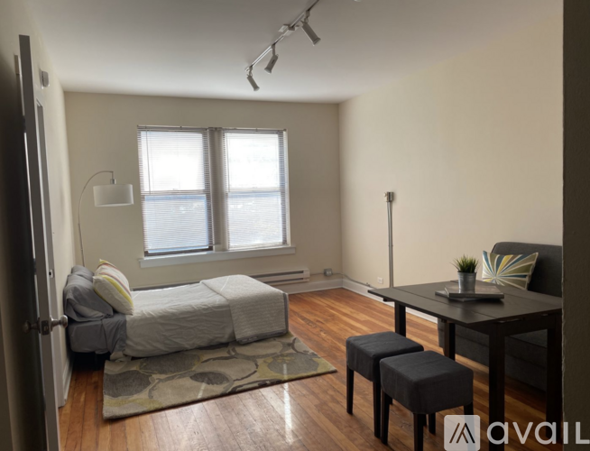 A bedroom with a bed, a table, and a window.