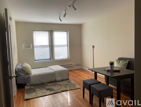 A bedroom with a bed, a table, and a window.