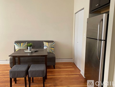 A modern dining area with a grey table and two grey stools.