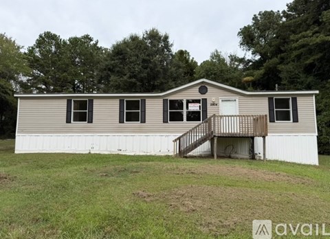 A mobile home with a porch and a small deck.