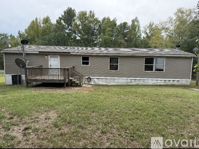 A house with a satellite dish on the roof and a deck.
