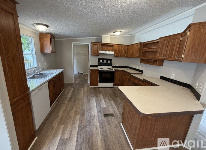 A kitchen with wooden cabinets and a countertop is available.