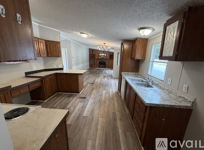 A kitchen with wooden cabinets and a marble countertop.