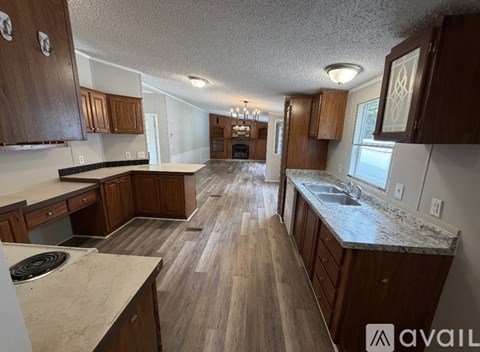 A kitchen with wooden cabinets and a marble countertop.