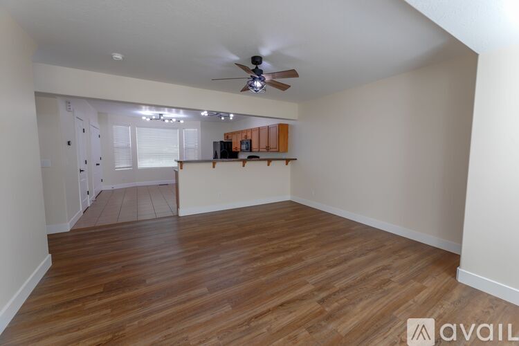 A room with wooden flooring and a ceiling fan.