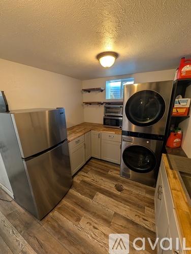 A kitchen with a stainless steel refrigerator and a washing machine.