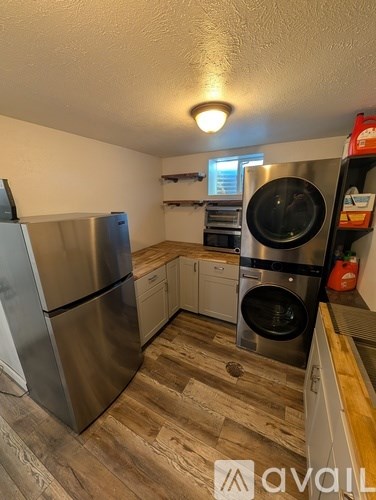 A kitchen with a stainless steel refrigerator and a washing machine.