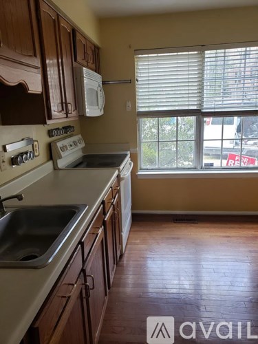 A kitchen with wooden cabinets and a window.