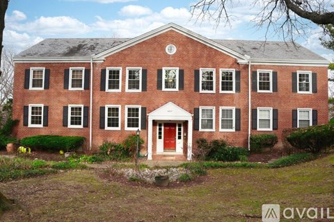 A red brick house with a white door and windows.