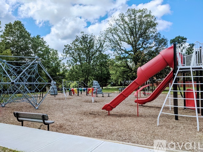 A playground with a red slide and a metal structure.
