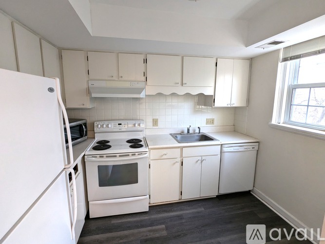 A kitchen with white appliances and cabinets.
