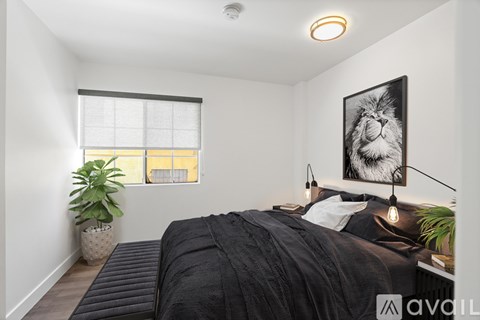 A bedroom with a large bed and a picture of a lion on the wall.