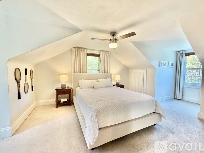 A bedroom with a large bed and a ceiling fan.