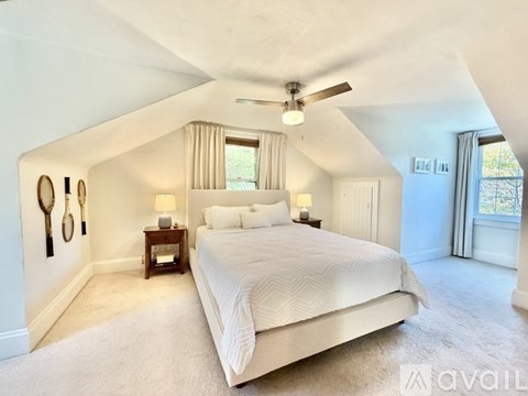 A bedroom with a large bed and a ceiling fan.