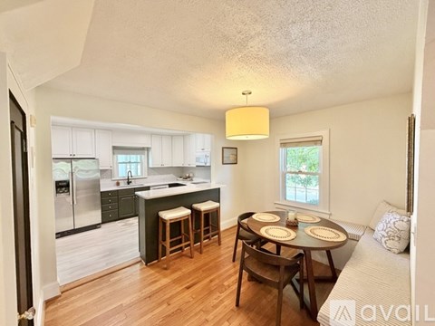 A kitchen with a table and chairs in the middle of the room.