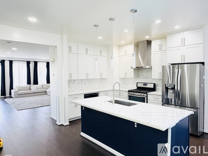 A modern kitchen with a large island and stainless steel appliances.
